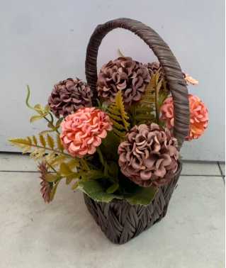 Arreglo floral decorativo en canasto con asa